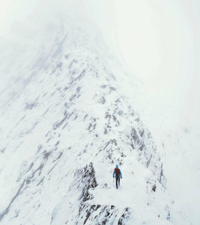 Mountaineer using an ice axe to climb Forcan Ridge in Glen Shiel, Scotland